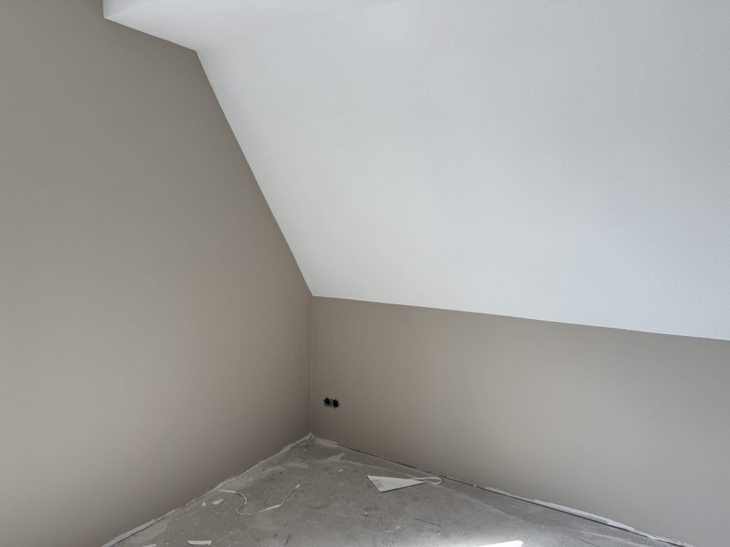 Zolderkamer met een schuine wand en lichte, egale muren